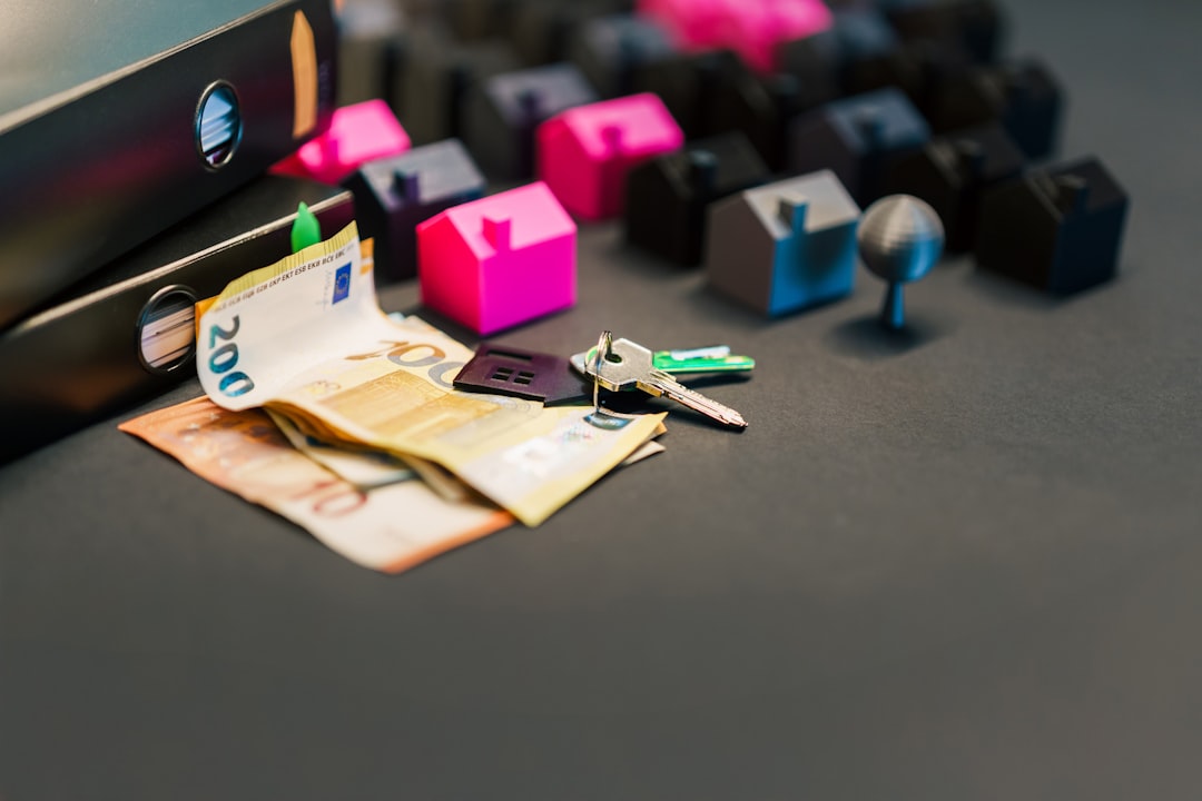 Person sits at a clean, modern desk, using a calculator to review financial documents related to selling a home, with a se...