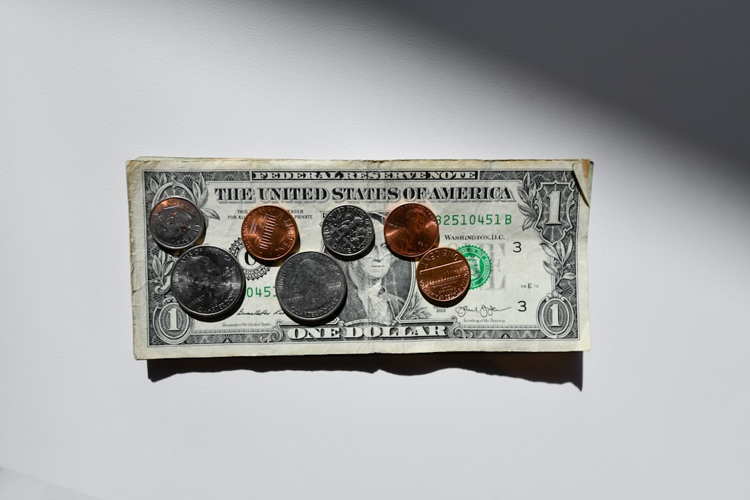 A clean, minimalist photo from above showing hands dividing a stack of cash into two piles, visually representing the 50/50 real estate commission split.