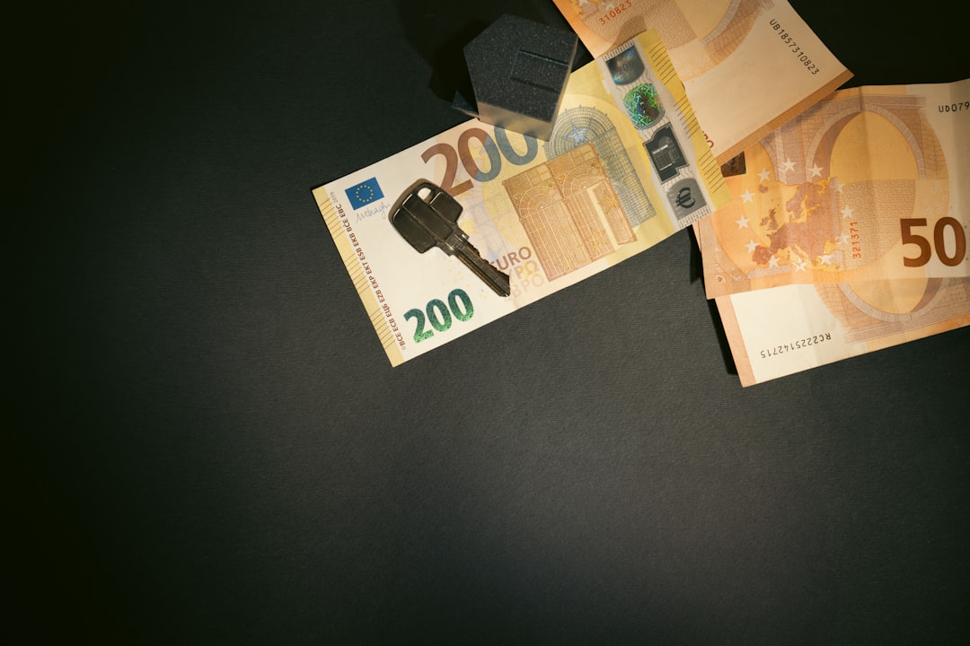 A clean, minimalist photo showing a set of house keys placed next to a piggy bank, visually representing the concept of saving money on real estate commissions.