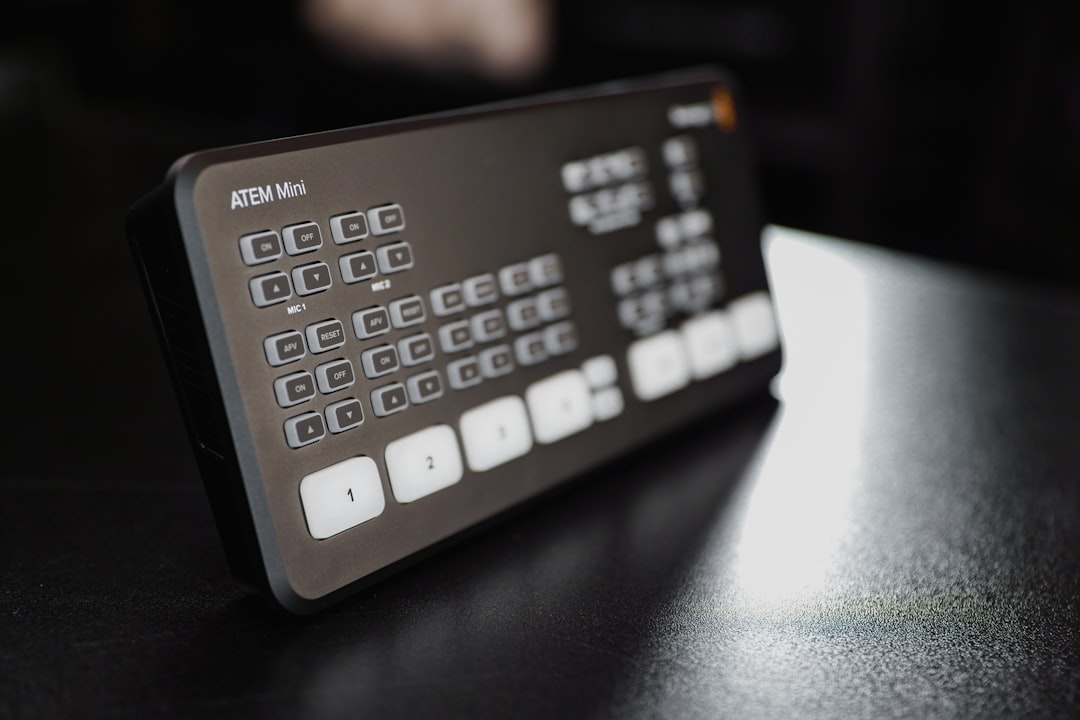 A person sits at a sunlit modern kitchen table with a laptop, calculator, and documents, carefully planning the finances for their home sale.