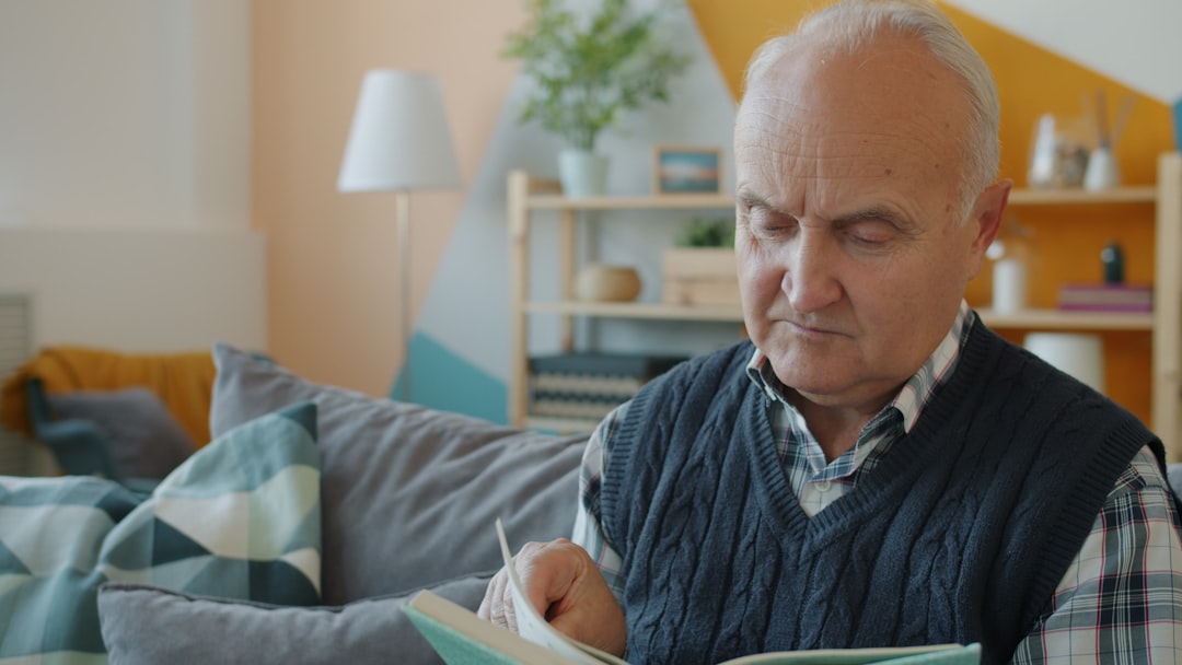 A serious couple sits at their kitchen table with a laptop and documents, looking concerned as they review the high costs associated with selling their home.