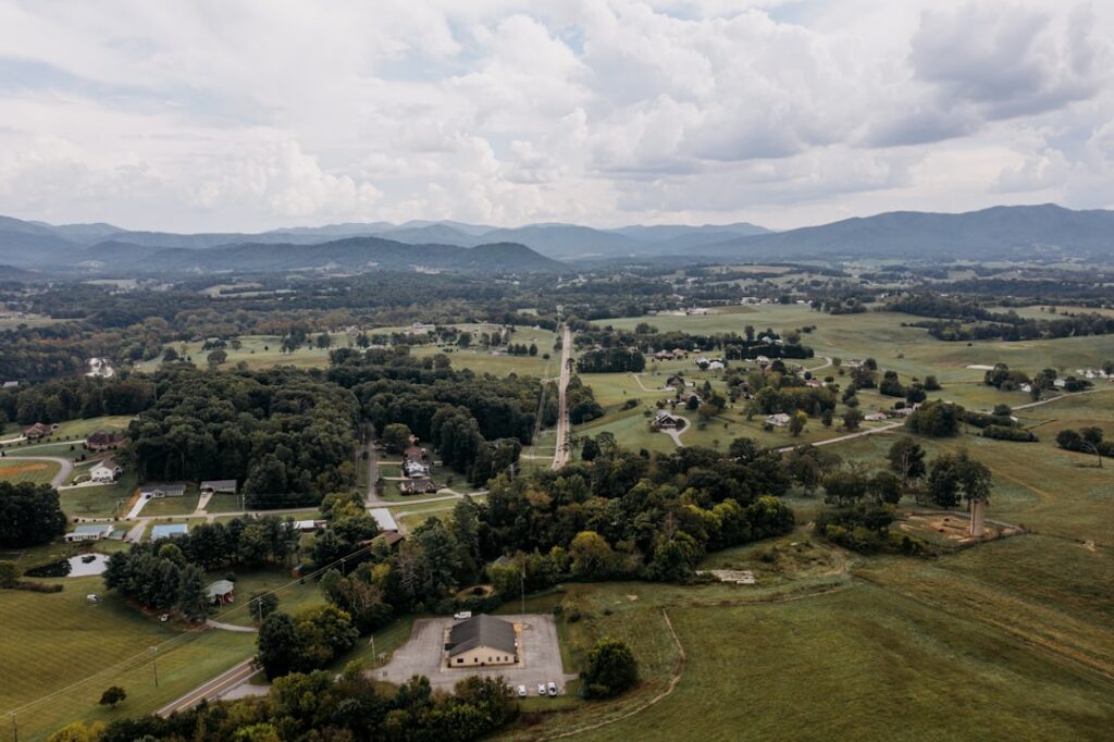 Beautiful modern home with a manicured lawn, set against the scenic backdrop of rolling Tennessee hills on a sunny day.
