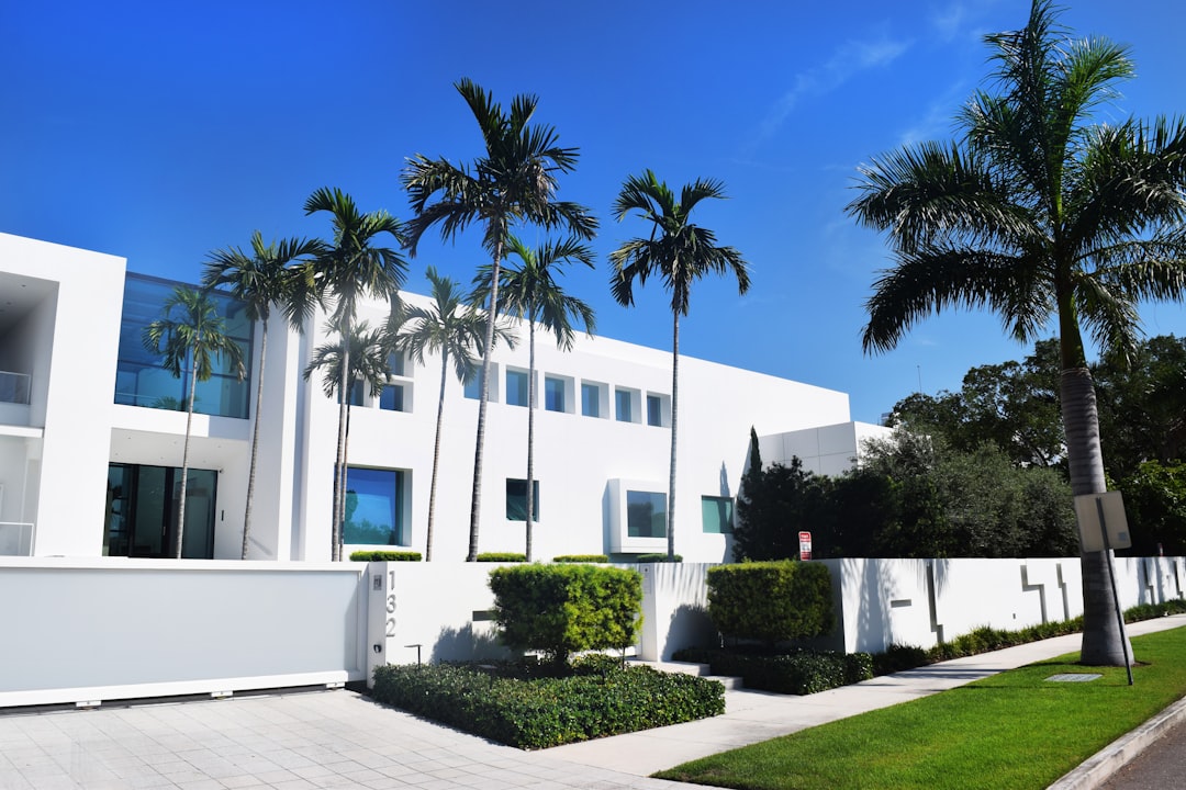 The exterior of a beautiful modern home with a well-manicured green lawn and landscaping, symbolizing the growth of wealth and the value of a real estate investment.