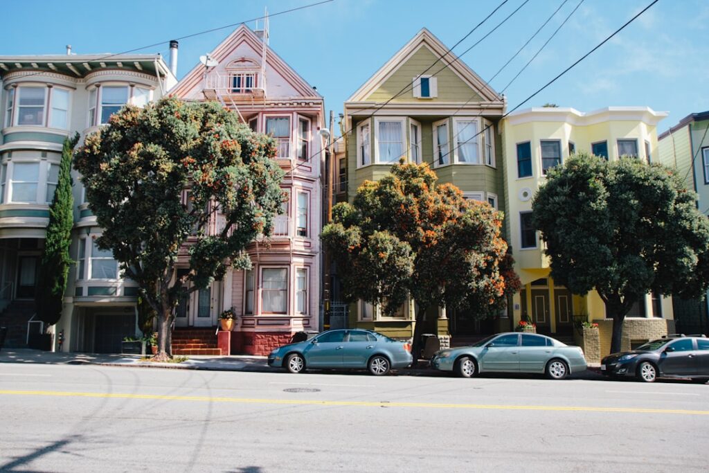 Bright, sunny day on a beautiful tree-lined residential street, showcasing a variety of charming homes from historic to mo...