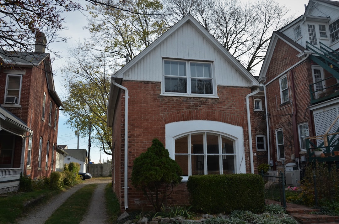 A side-by-side view of a sleek, modern home and a classic, historic brick home, visually representing the choice between urban and suburban lifestyles.