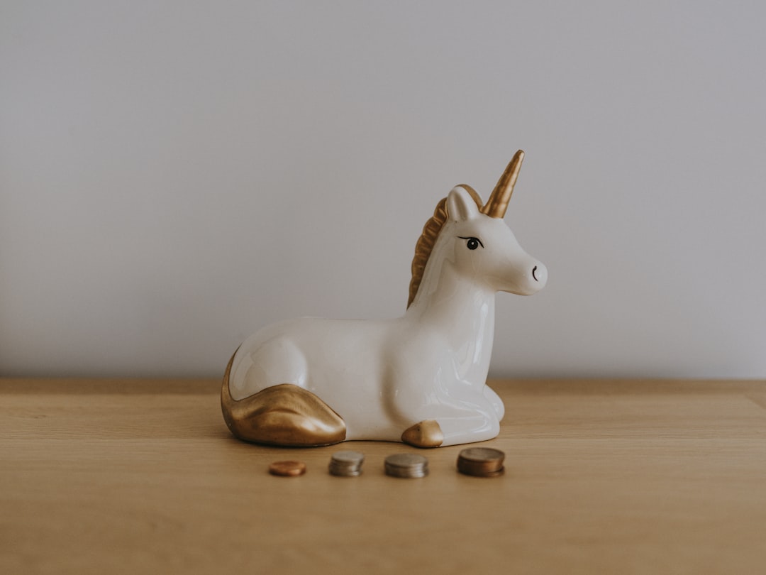 Modern, minimalist piggy bank sitting next to a set of house keys on a bright, clean surface, symbolizing savings in real ...