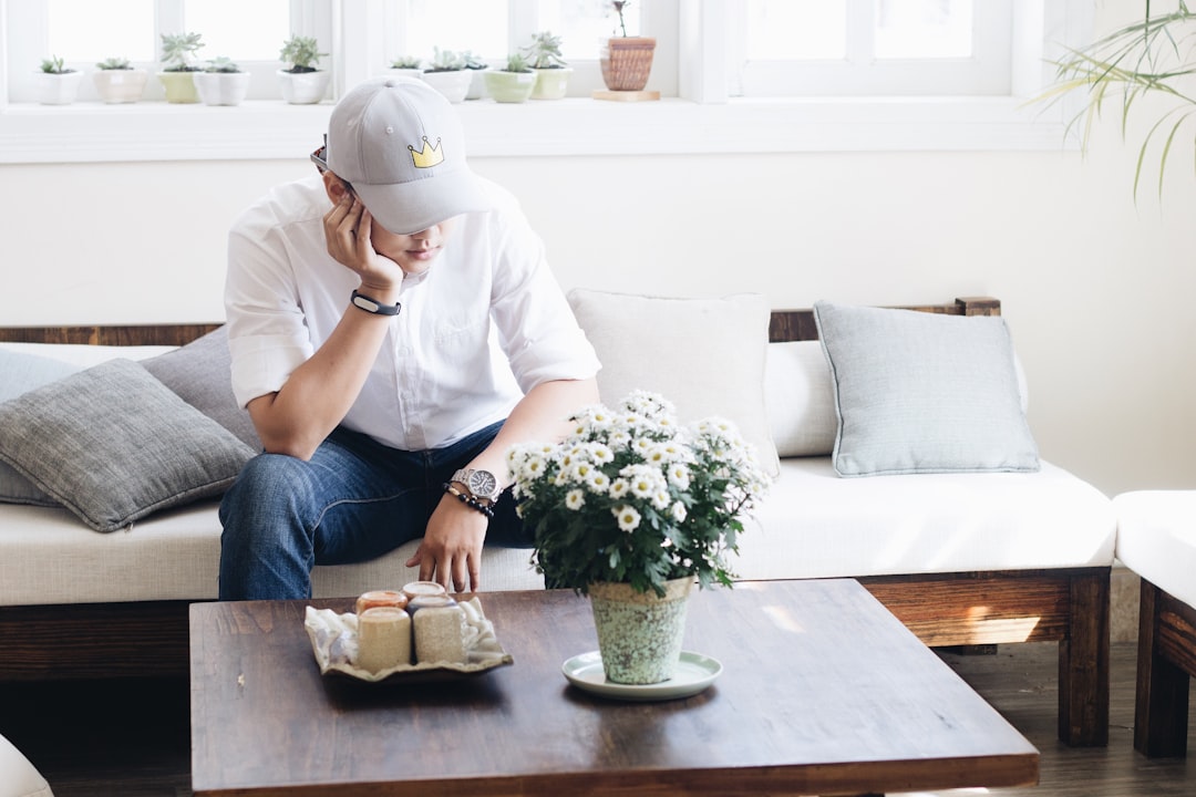 A relieved and happy homeowner relaxing in their sunny, modern living room, symbolizing the financial peace of mind from saving thousands on commission fees.