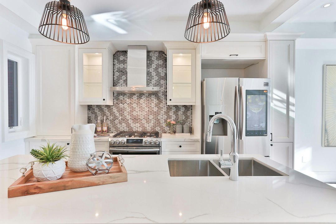 Bright, modern kitchen in the middle of a renovation, with tools and unfinished cabinets visible, representing the cost of...