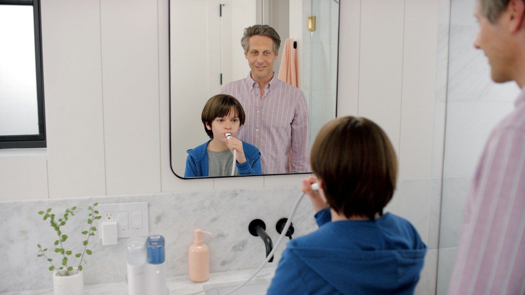 A happy couple enjoying their newly renovated, spa-like modern bathroom, a tangible result of funding a project by ditching the 6% real estate commission.